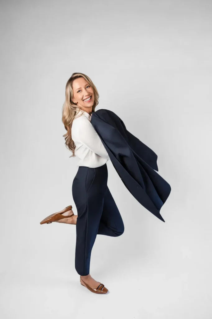 Maya Cakar smiling mid-step with her jacket over her shoulder