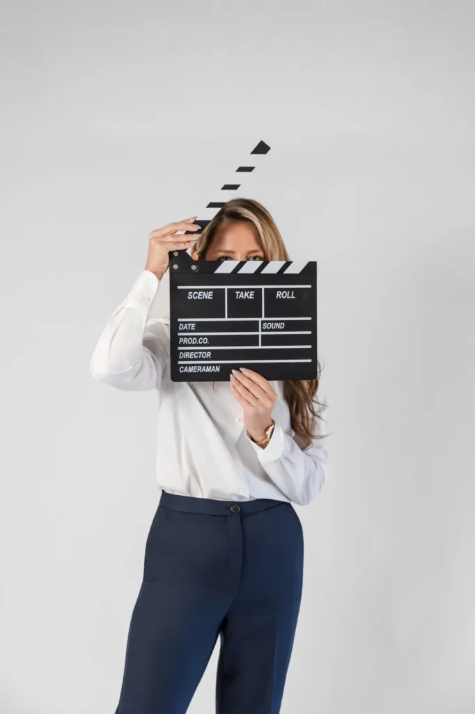 Maya Cakar holding a film clapperboard for a content shoot